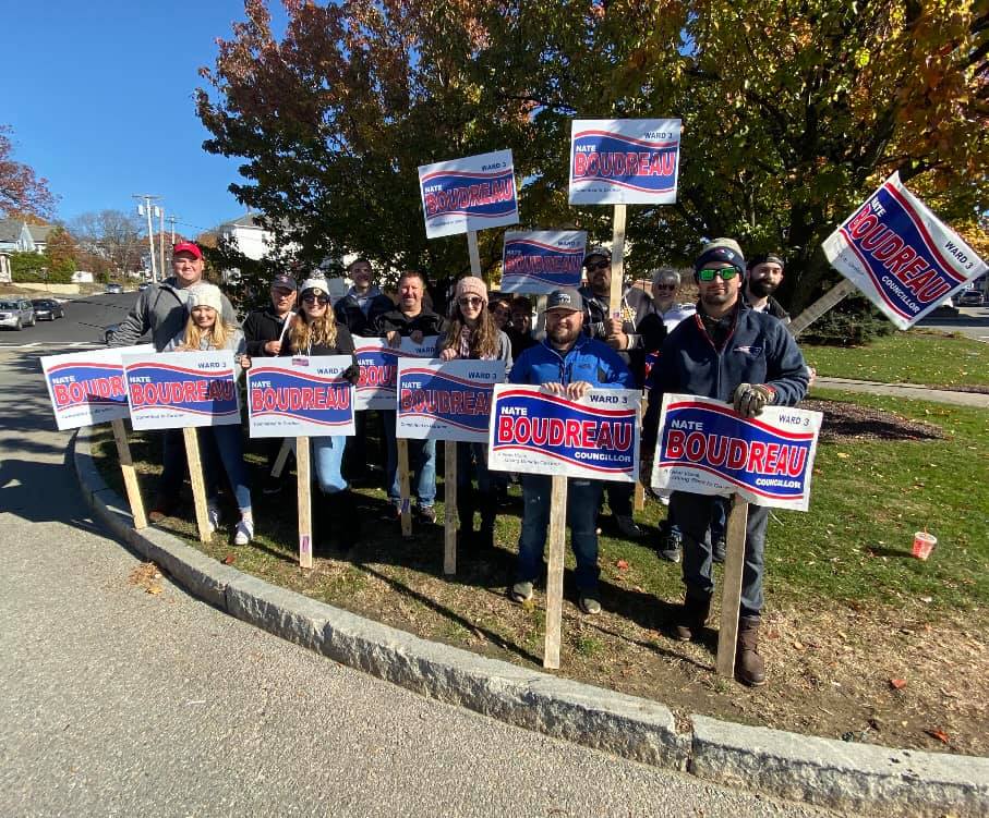 Nate Boudreau and his campaign team holding signs at a community sign-waving event